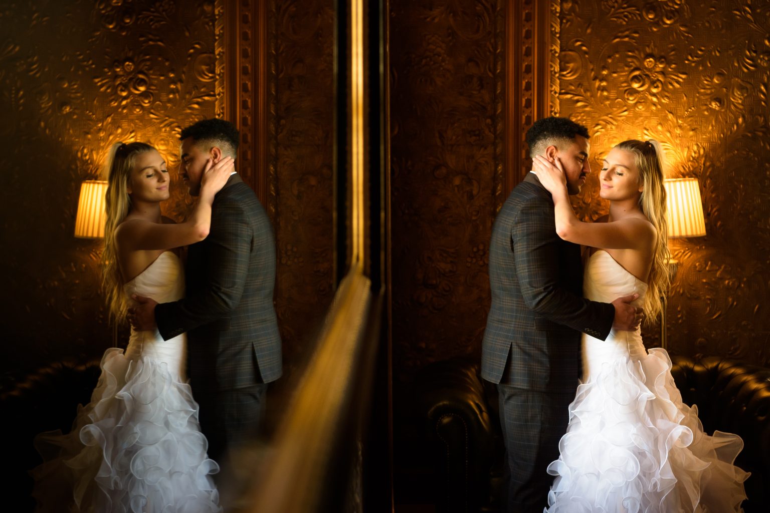 a smiling bride and groom photographed next to a mirror by tom sutherland