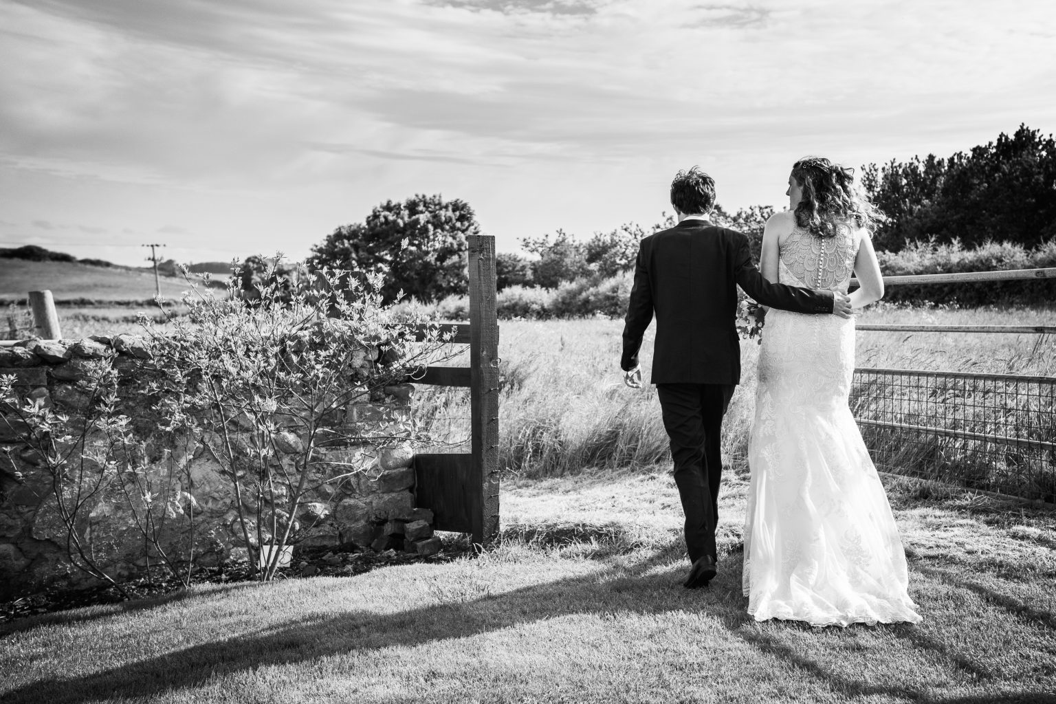 hull wedding photographer captures a bride and groom casually walking through a field