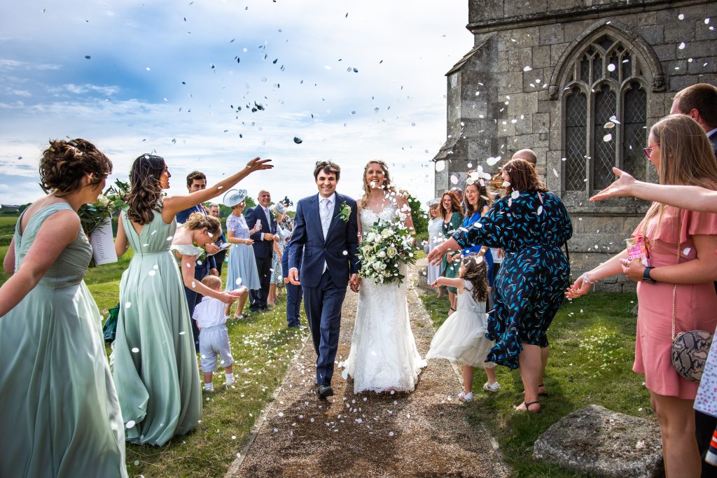 confetti is thrown on a married couple outside skipsea church