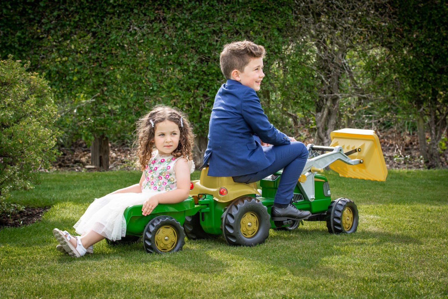 children play on a plastic tractor at an outdoor wedding reception near hull