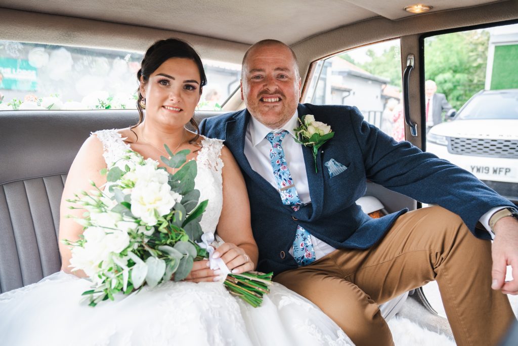 a newlywed couple in their wedding car photographed by hull wedding photographer tom sutherland