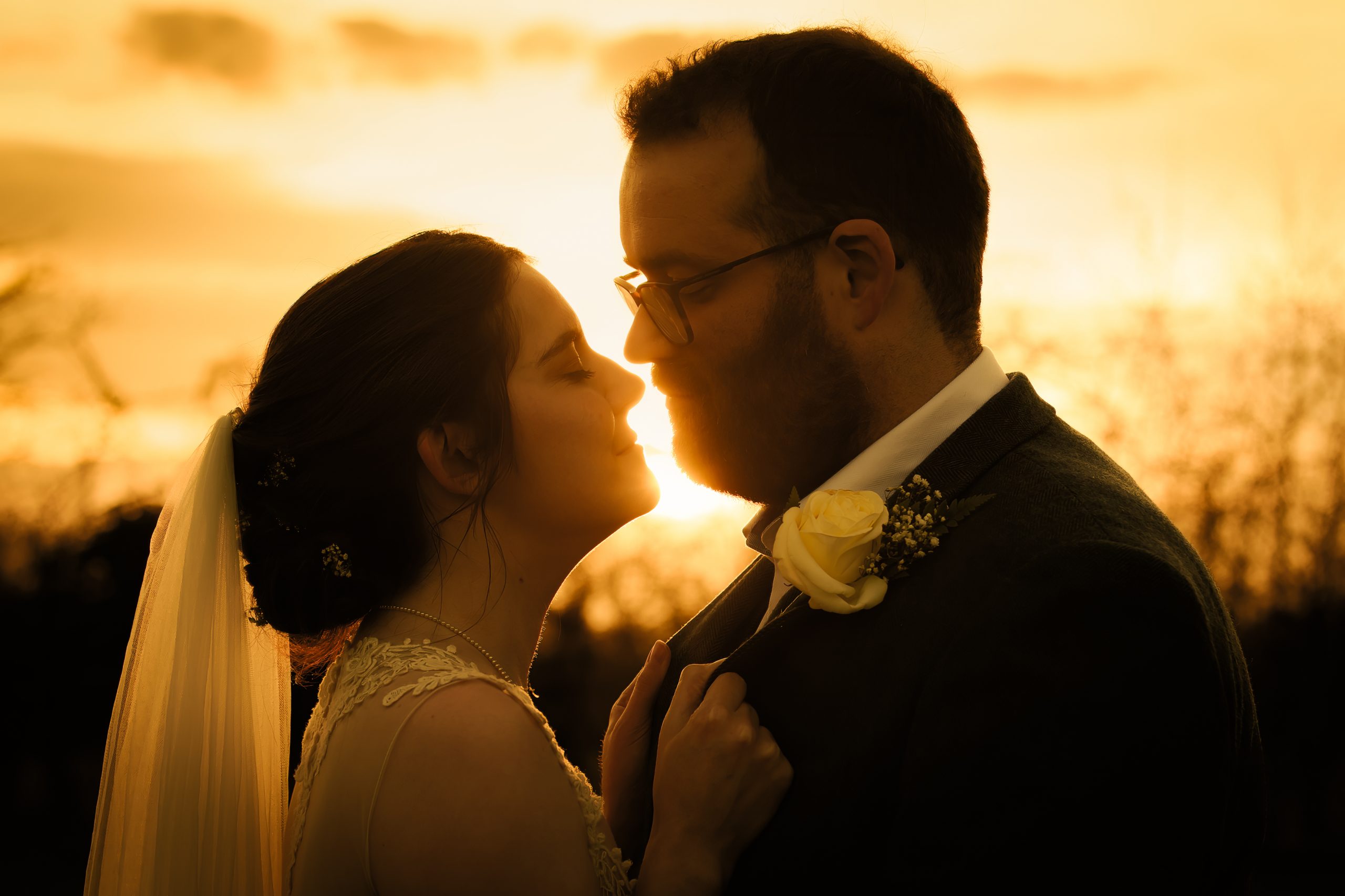 a married couple embrace in the golden hour at the triton inn brandesburton