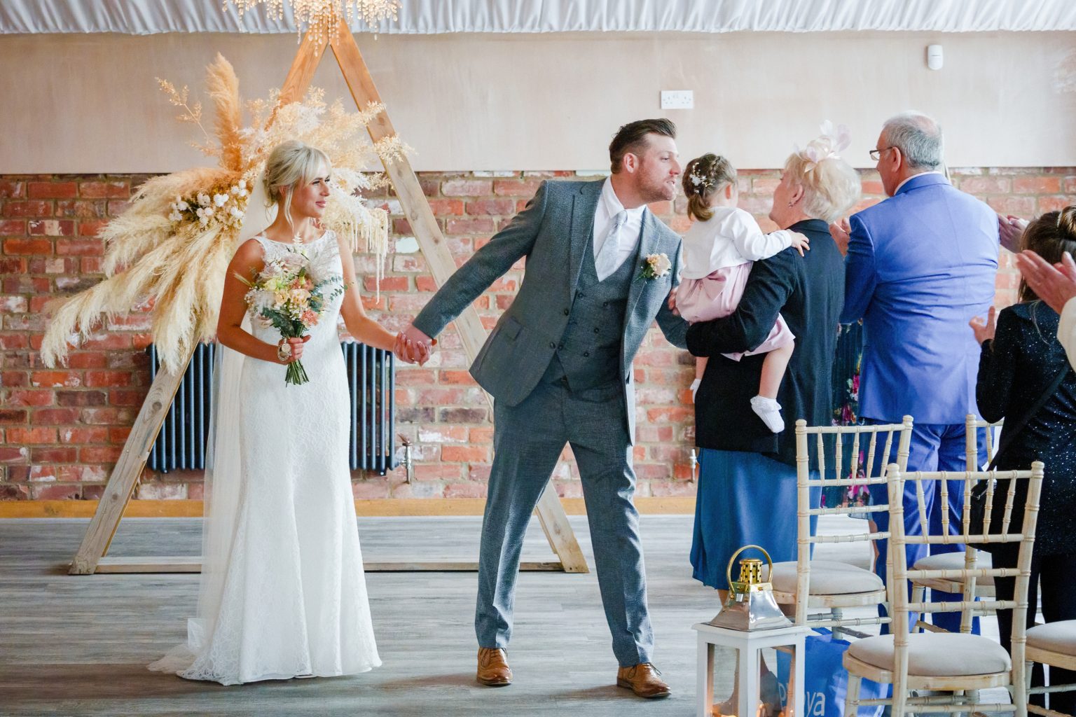 a groom kissing his daughter during his wedding ceremony at the barn at willerby hill east yorkshire scaled