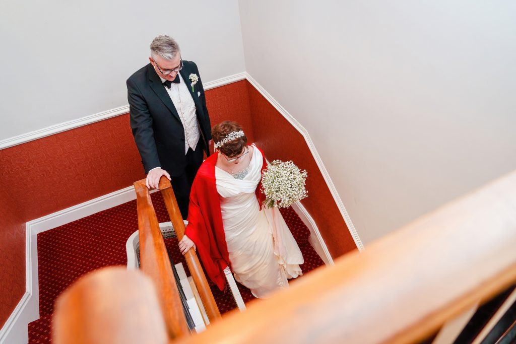 bride and groom walking down the stairs at minerva masonic lodge hull scaled