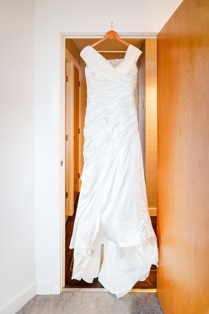 brides dress hanging in doorway before her wedding in hull scaled