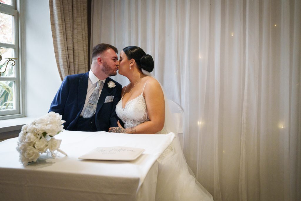 wedding couple kiss after signing the register at lazaat hotel near hull scaled