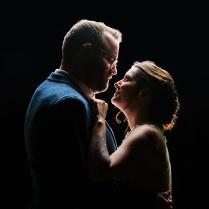 wedding photographer captures a newly married couple kissing beneath a lantern